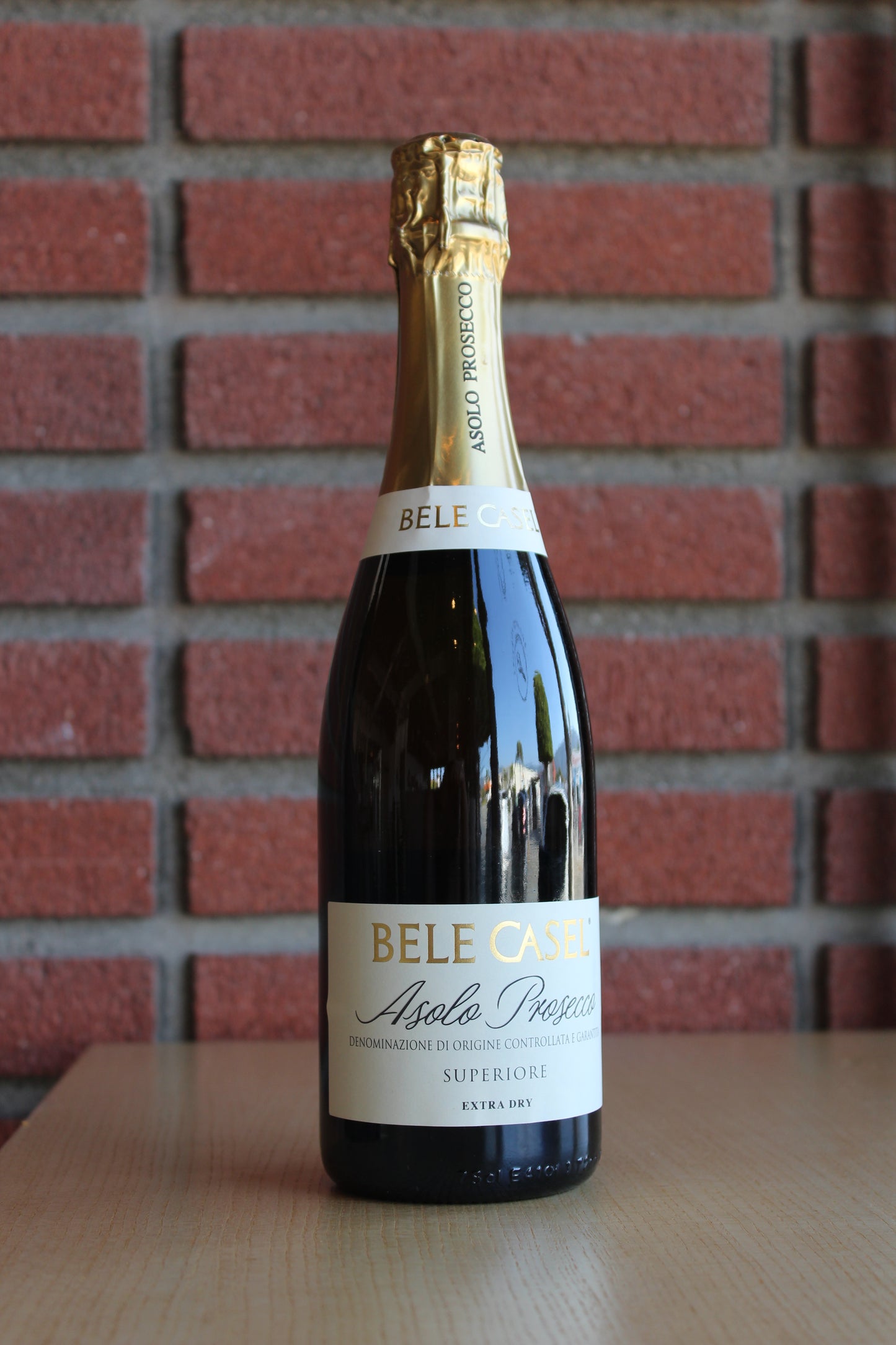 Bele Casel Asolo Prosecco Superiore Extra Brut Bottle against a brick background