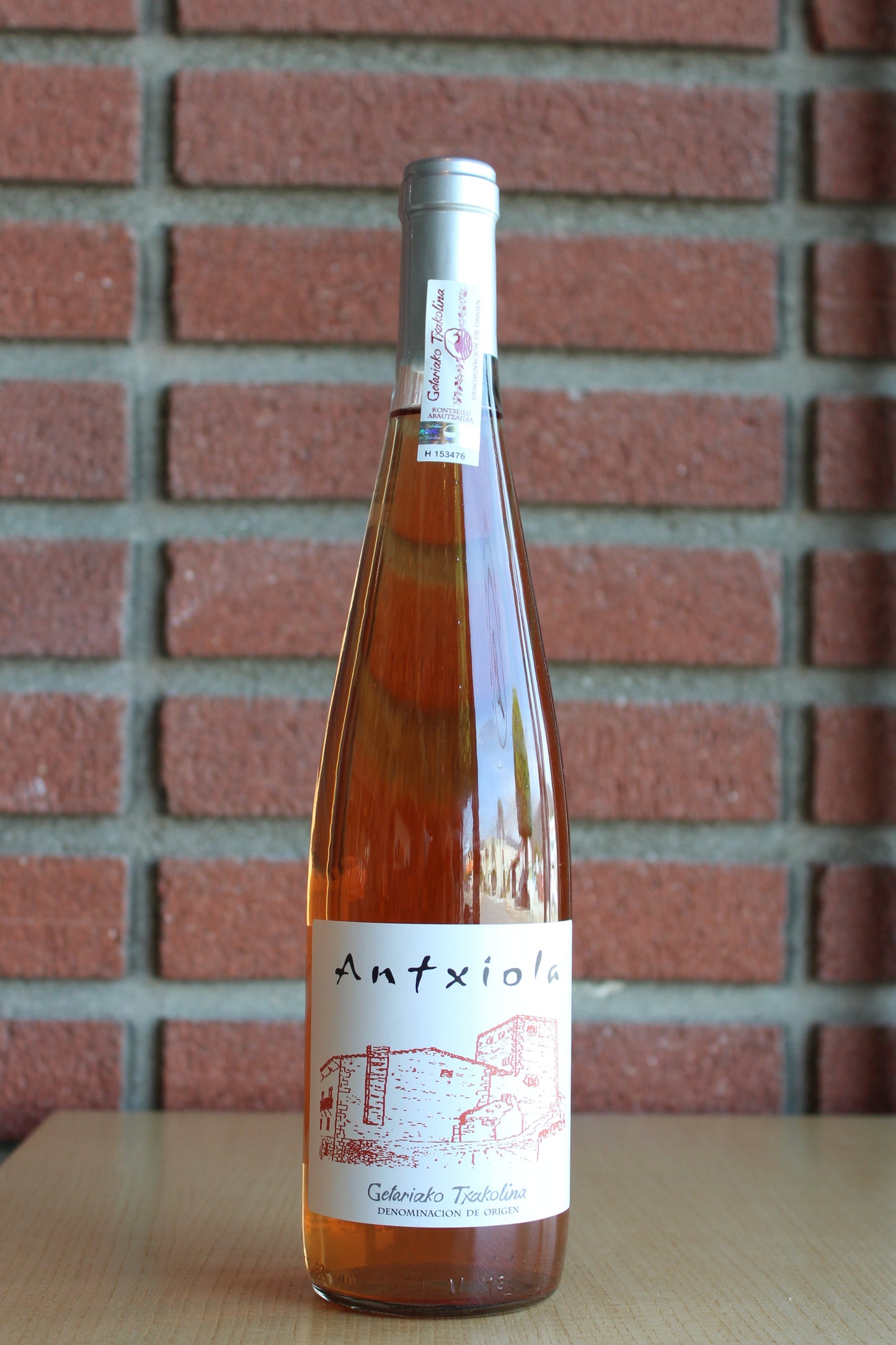 Bodegas Zudugarai “Antxiola” Txakolina Rosé Bottle on a brick background