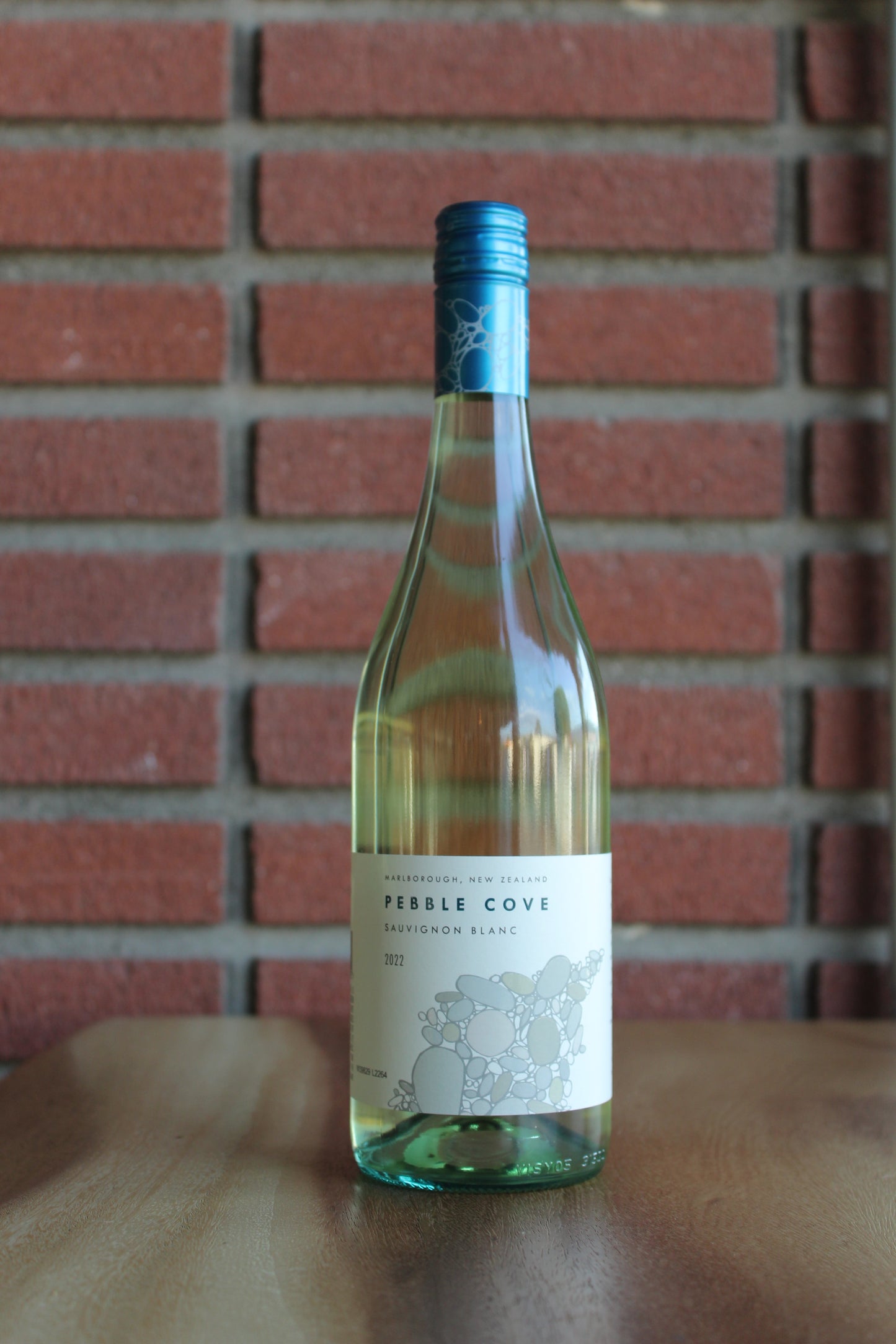 pebble cove sauvignon blanc bottle on a brick background