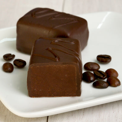 john kelly dark chocolate espresso fudge bars on a white plate with coffee beans