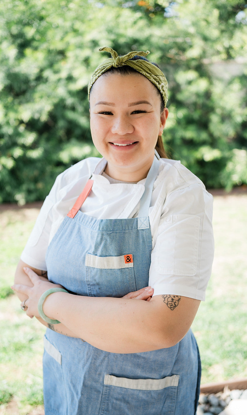 Person wearing a blue apron with a garden background