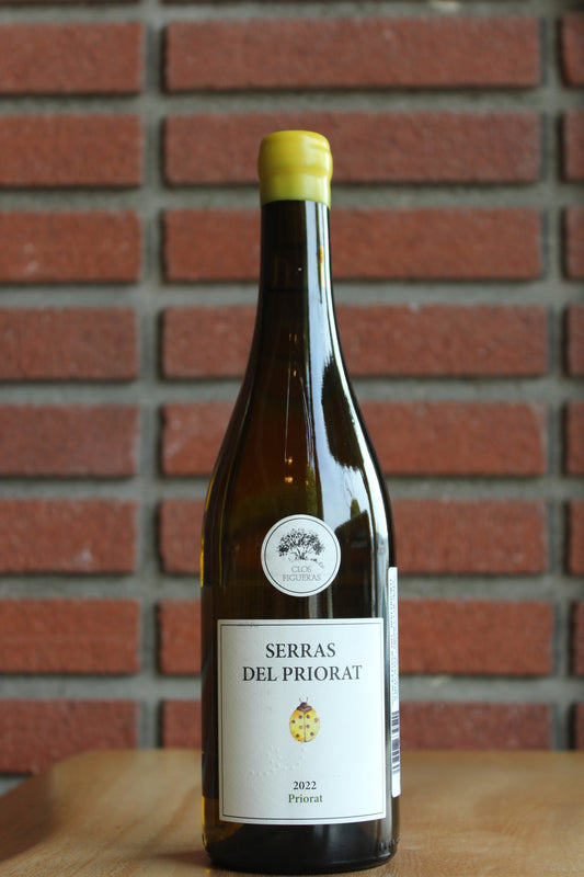 Wine bottle labeled 'Serras del Priorat' by Clos Figueras against a brick wall background