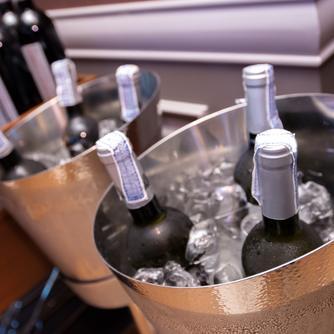 white wine bottles in wine chillers filled with ice