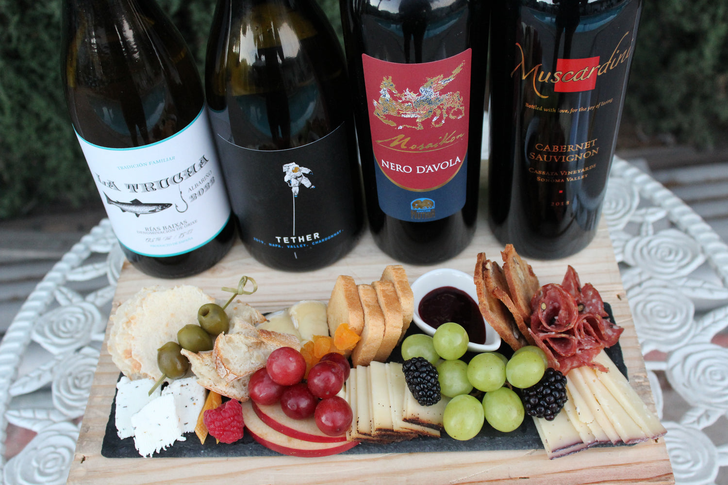 Assorted wines with a charcuterie board on a textured surface