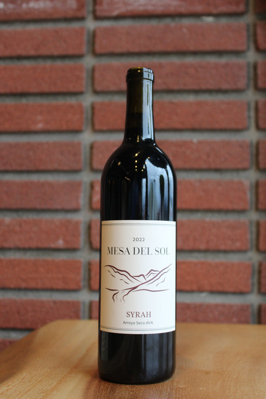 Bottle of Mesa del Sol Syrah 2022 wine on a red brick background