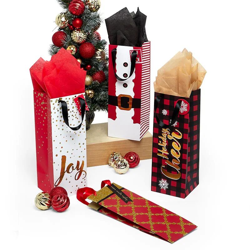assorted holiday and christmas wine bags with tissue paper, a decorated christmas tree, and ornaments