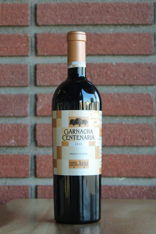 Bottle of Bodegas Aragonesas Coto de Hayas Centenaria Garnacha 2022 wine with a red brick background